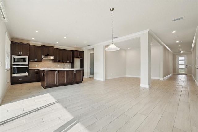 2785 Park Ridge St, Apopka, FL 32712 - kitchen with appliances with stainless steel finishes, under cabinet range hood, open floor plan, light countertops, and crown molding