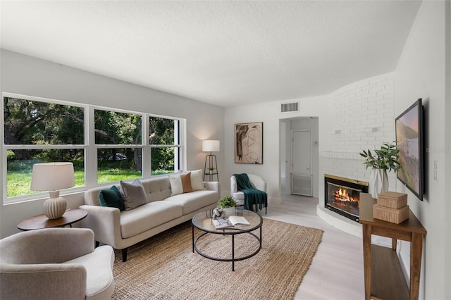 239 S Lake Cortez Dr, Apopka, FL 32703 - living area featuring a brick fireplace, a textured ceiling, and light wood finished floors