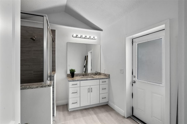 239 S Lake Cortez Dr, Apopka, FL 32703 - bathroom with vaulted ceiling, a textured ceiling, vanity, wood finished floors, and tiled shower