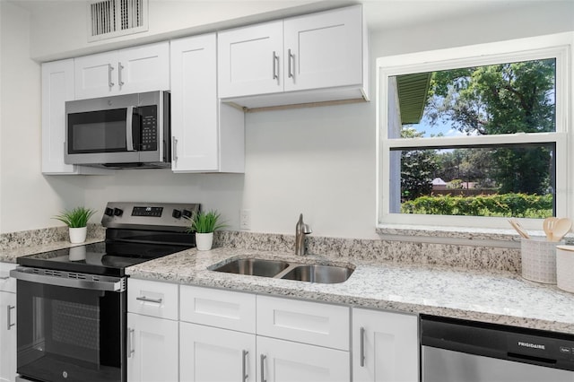 239 S Lake Cortez Dr, Apopka, FL 32703 - kitchen featuring appliances with stainless steel finishes, a sink, white cabinets, and light stone countertops