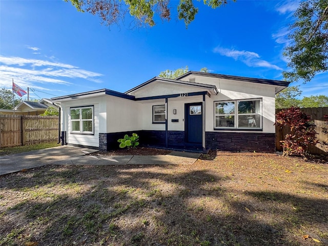 1121 49th Ave N, Saint Petersburg, FL 33703 - view of front of home with stone siding, fence, and stucco siding