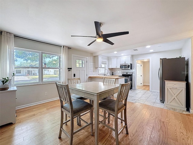 1121 49th Ave N, Saint Petersburg, FL 33703 - dining space featuring a ceiling fan, baseboards, and light wood-type flooring