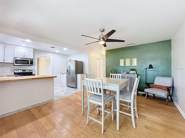 1121 49th Ave N, Saint Petersburg, FL 33703 - dining space with light wood-type flooring, visible vents, baseboards, and ceiling fan