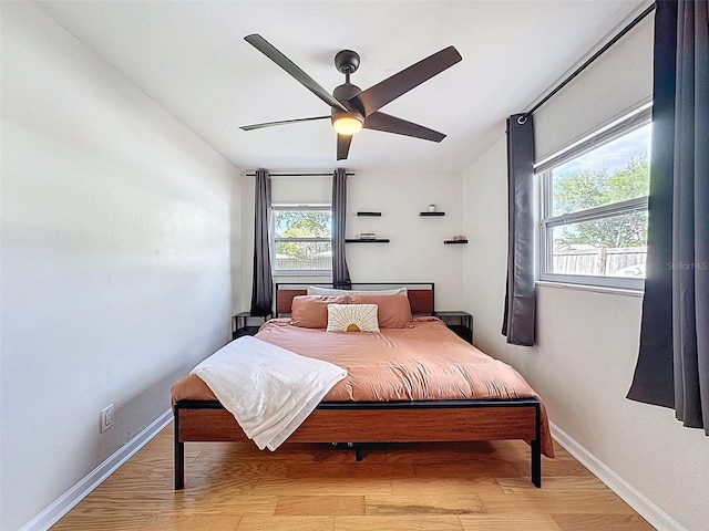 1121 49th Ave N, Saint Petersburg, FL 33703 - bedroom featuring a ceiling fan, baseboards, and light wood-style floors