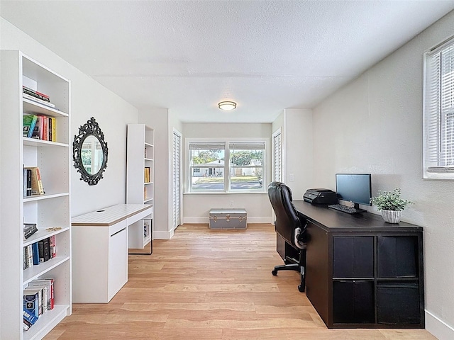 1121 49th Ave N, Saint Petersburg, FL 33703 - home office with baseboards, light wood-type flooring, and a textured ceiling