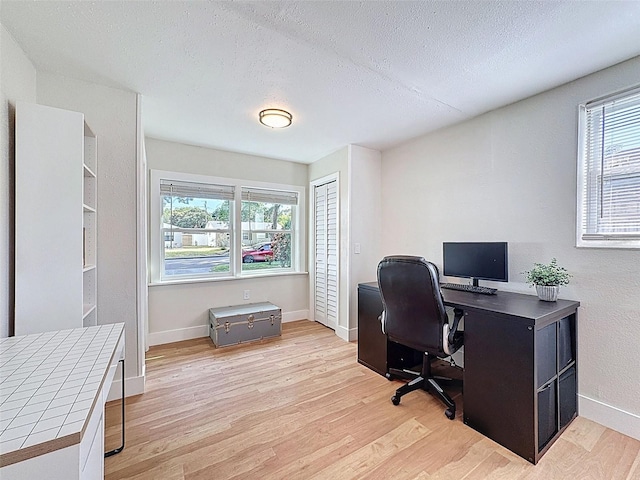 1121 49th Ave N, Saint Petersburg, FL 33703 - office area featuring baseboards, light wood finished floors, and a textured ceiling