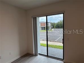 3296 Tranquil Trl, Kissimmee, FL 34747 - doorway to outside featuring light wood-style flooring and baseboards