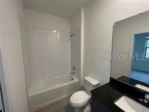 3296 Tranquil Trl, Kissimmee, FL 34747 - bathroom featuring vanity, toilet, and shower / washtub combination