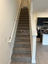 3296 Tranquil Trl, Kissimmee, FL 34747 - staircase featuring wood finished floors