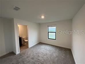 3296 Tranquil Trl, Kissimmee, FL 34747 - unfurnished bedroom featuring carpet floors and baseboards
