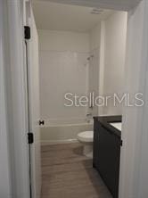 3296 Tranquil Trl, Kissimmee, FL 34747 - full bathroom with vanity, washtub / shower combination, toilet, and wood finished floors