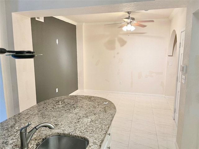 911 N Orange Ave Unit 424, Orlando, FL 32801 - kitchen with crown molding, light stone counters, ceiling fan, and a sink