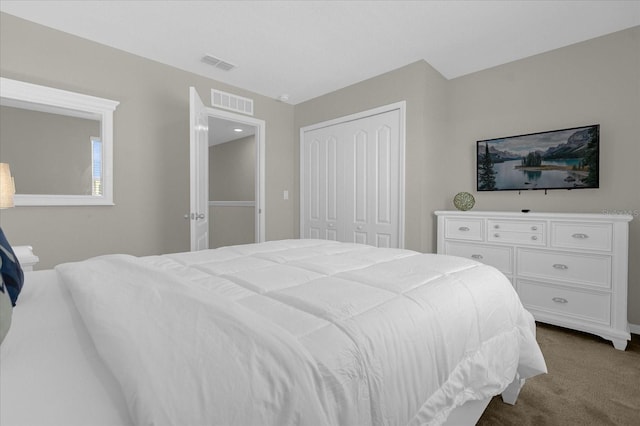 bedroom featuring dark carpet, visible vents, and a closet