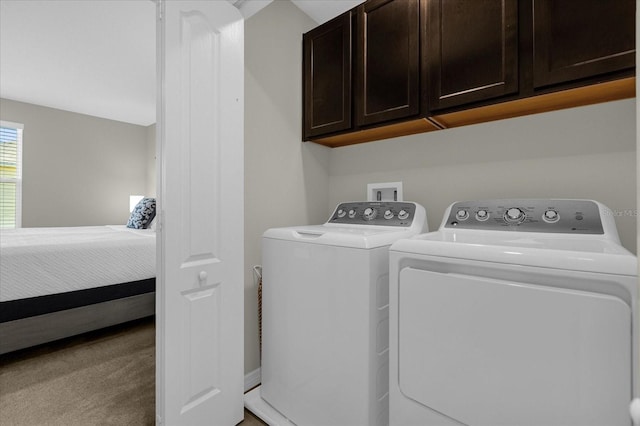 clothes washing area with washing machine and clothes dryer, cabinet space, and carpet flooring