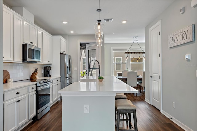 12330 Koshiba Aly, Orlando, FL 32827 - kitchen with a sink, backsplash, a breakfast bar area, appliances with stainless steel finishes, and visible vents