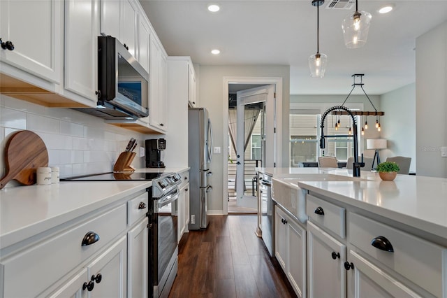 12330 Koshiba Aly, Orlando, FL 32827 - kitchen with white cabinetry, light countertops, decorative backsplash, dark wood-style floors, and appliances with stainless steel finishes