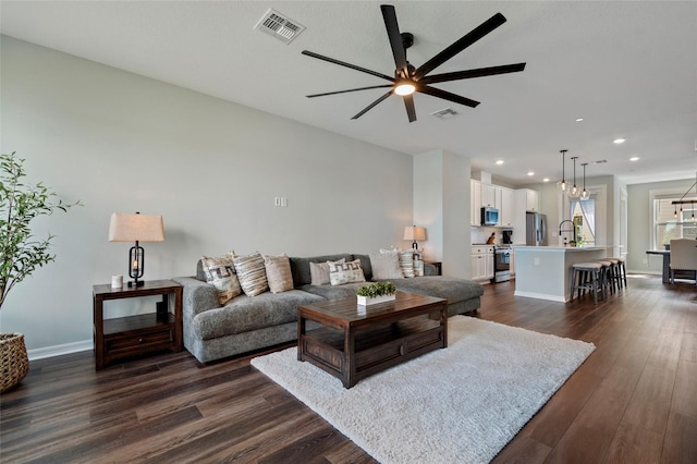 12330 Koshiba Aly, Orlando, FL 32827 - living room featuring dark wood-style flooring, baseboards, ceiling fan, and visible vents