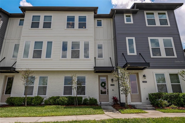 12330 Koshiba Aly, Orlando, FL 32827 - townhome / multi-family property with board and batten siding and brick siding