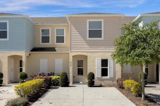 view of property with stucco siding and a shingled roof