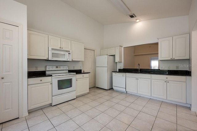 39900 Bayview Dr, Lady Lake, FL 32159 - kitchen featuring white appliances, high vaulted ceiling, a sink, dark countertops, and visible vents