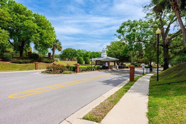39900 Bayview Dr, Lady Lake, FL 32159 - view of street featuring curbs, a gated entry, street lighting, and sidewalks