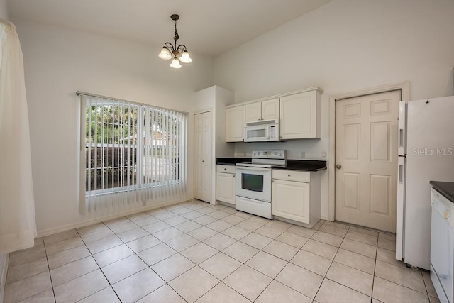39900 Bayview Dr, Lady Lake, FL 32159 - kitchen with decorative light fixtures, white appliances, an inviting chandelier, light tile patterned floors, and dark countertops