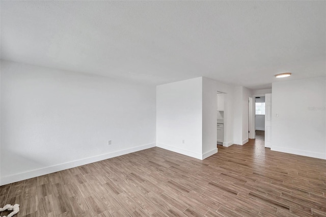 unfurnished room with light wood-style flooring and baseboards