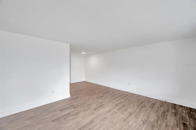 unfurnished room with light wood-type flooring and baseboards
