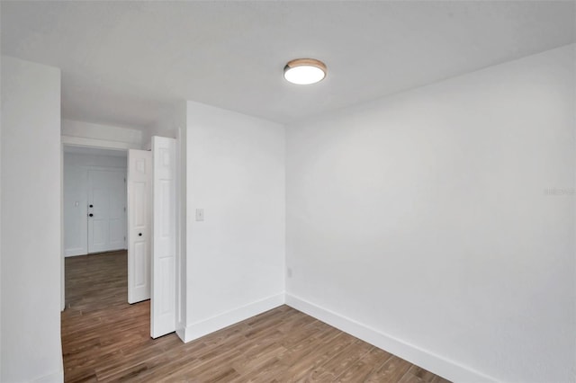empty room featuring baseboards and light wood finished floors