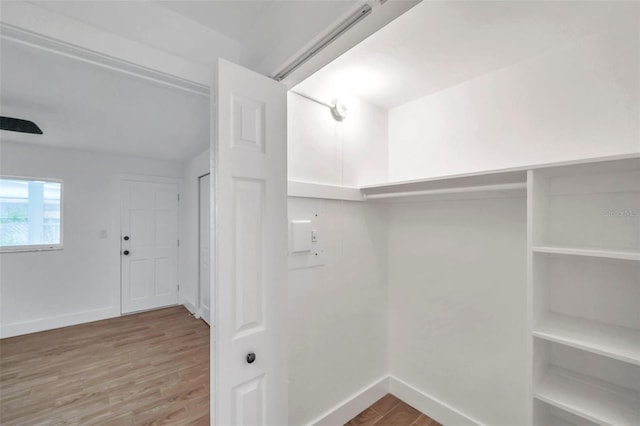 walk in closet with wood finished floors