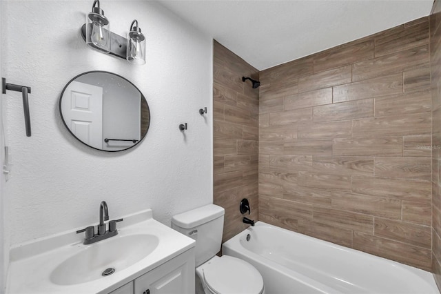 bathroom with toilet, vanity, a textured wall, and washtub / shower combination