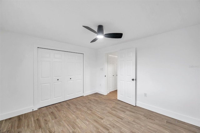 unfurnished bedroom featuring a closet, baseboards, light wood finished floors, and ceiling fan