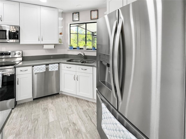 11404 Lokanotosa Trl, Orlando, FL 32817 - kitchen featuring open shelves, a sink, light wood-style floors, white cabinets, and appliances with stainless steel finishes