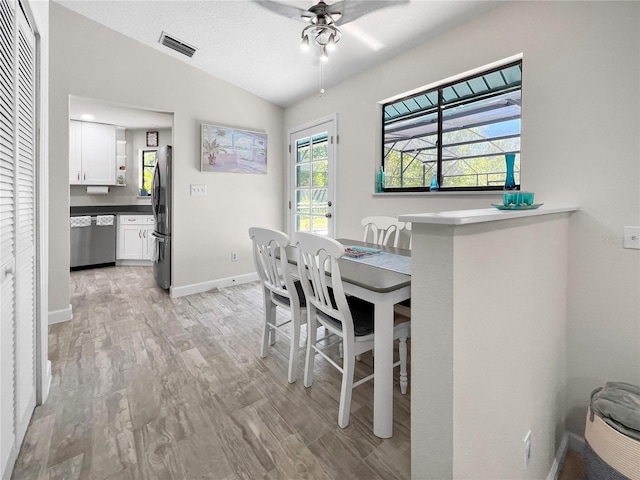 11404 Lokanotosa Trl, Orlando, FL 32817 - dining room featuring vaulted ceiling, light wood-type flooring, baseboards, ceiling fan, and visible vents