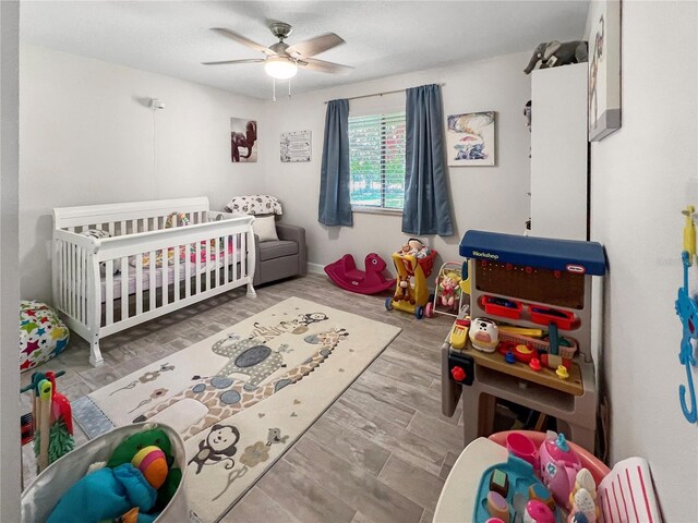 11404 Lokanotosa Trl, Orlando, FL 32817 - bedroom featuring ceiling fan, wood finished floors, and a crib