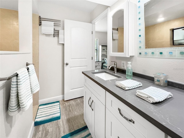 11404 Lokanotosa Trl, Orlando, FL 32817 - full bathroom with baseboards, wood finished floors, a walk in shower, and vanity