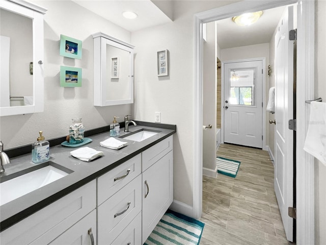 11404 Lokanotosa Trl, Orlando, FL 32817 - bathroom featuring double vanity, a sink, baseboards, and bathtub / shower combination