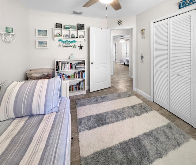 11404 Lokanotosa Trl, Orlando, FL 32817 - bedroom featuring baseboards, wood finished floors, a closet, and a ceiling fan