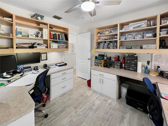 11404 Lokanotosa Trl, Orlando, FL 32817 - home office featuring light wood finished floors, a textured ceiling, visible vents, built in desk, and ceiling fan