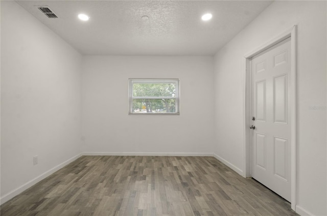 4385 Cassius St, Orlando, FL 32811 - empty room featuring wood finished floors, recessed lighting, baseboards, and a textured ceiling