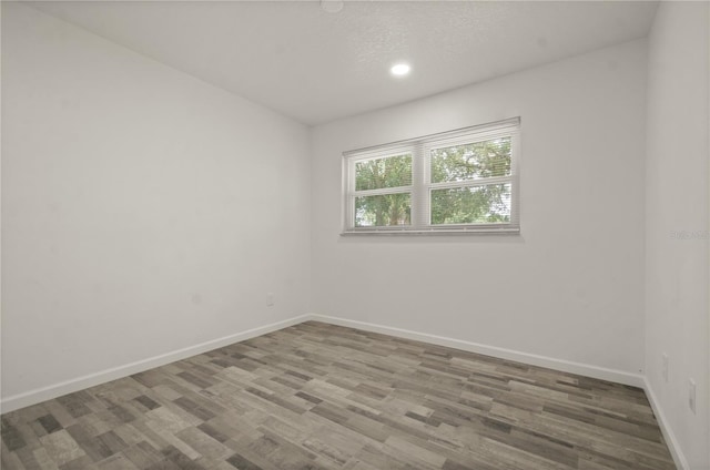 4385 Cassius St, Orlando, FL 32811 - empty room with baseboards, wood finished floors, recessed lighting, and a textured ceiling