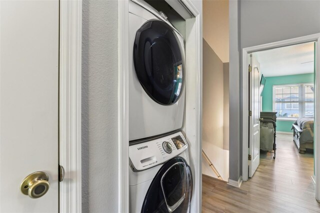 534 Wilton Cir, Sanford, FL 32773 - washroom with laundry area, baseboards, light wood-style flooring, and stacked washing maching and dryer