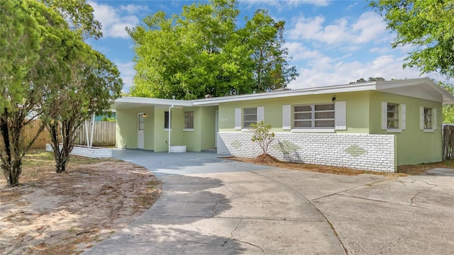 5201 Van Aken Dr, Orlando, FL 32808 - view of front facade with driveway, stucco siding, an attached carport, and fence