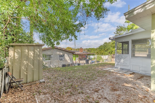 5201 Van Aken Dr, Orlando, FL 32808 - view of yard featuring a sunroom, fence, an outdoor structure, and a shed