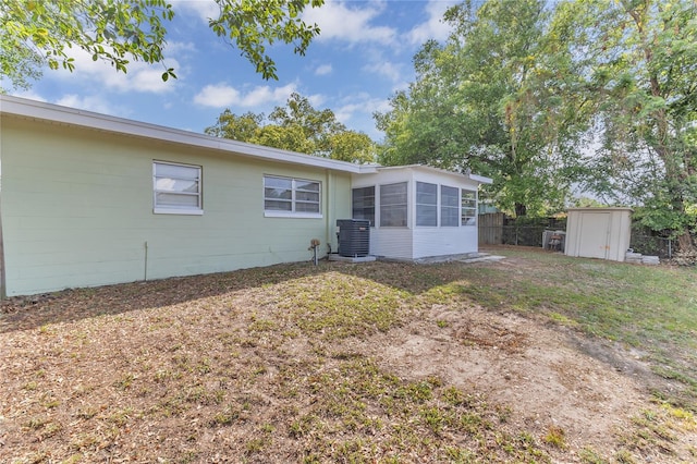 5201 Van Aken Dr, Orlando, FL 32808 - rear view of house featuring an outbuilding, a sunroom, a shed, central air condition unit, and fence