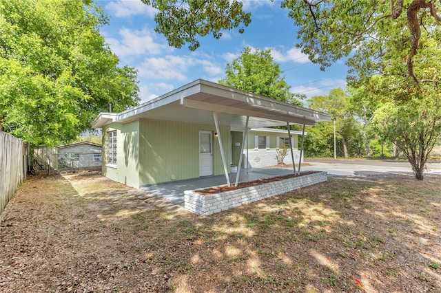5201 Van Aken Dr, Orlando, FL 32808 - rear view of property with an attached carport and fence