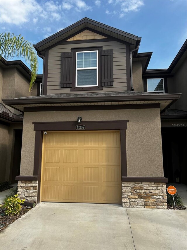 11826 Sky Acres Ter, Bradenton, FL 34211 - view of front of property featuring stone siding, an attached garage, concrete driveway, and stucco siding