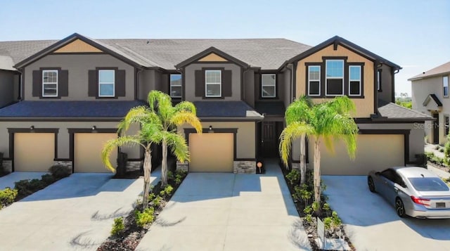 11826 Sky Acres Ter, Bradenton, FL 34211 - view of front of house featuring a garage, concrete driveway, stone siding, and stucco siding