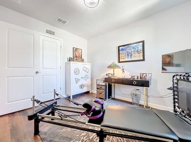 11826 Sky Acres Ter, Bradenton, FL 34211 - exercise room featuring a textured ceiling and wood finished floors