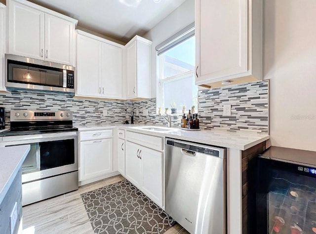 11826 Sky Acres Ter, Bradenton, FL 34211 - kitchen featuring appliances with stainless steel finishes, white cabinetry, backsplash, and light wood-type flooring